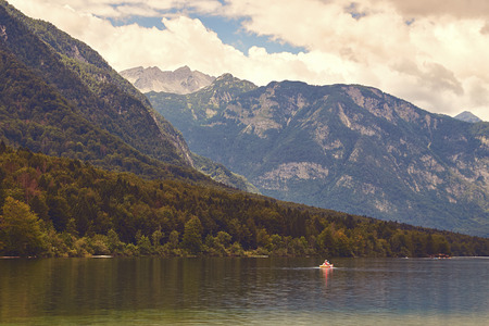 View of lake Bohinj with the boat sailing across itの写真素材