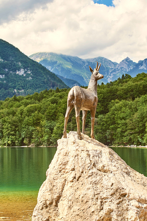 Ribcev Laz, Slovenia - July 04, 2017: Bronze statue of Goldhorn Zlatorog deer next to the Bohinj Lake in Triglav national parkのeditorial素材