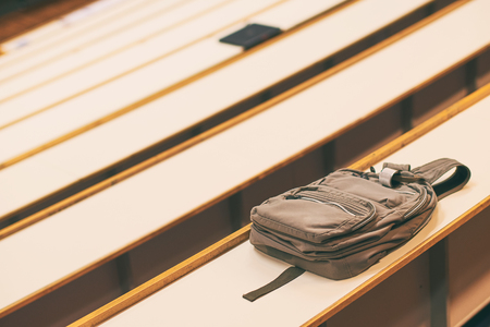 Student backpack bag on the desk in university auditoriumの写真素材