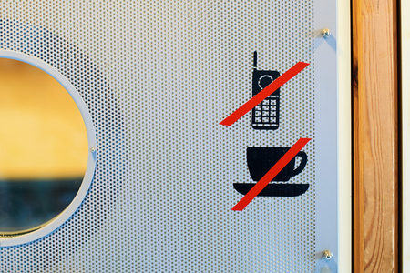 No coffee cup or drinks and mobile phone prohibition sign on the auditorium doorの写真素材