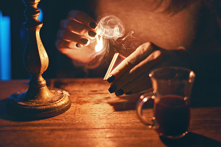 Woman hands igniting a last match from a matchboxの写真素材