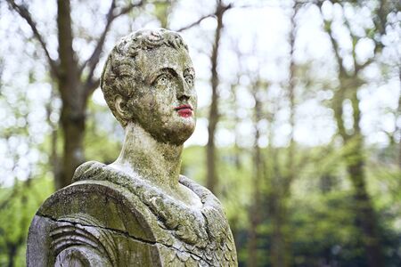 Old stone statue in Brussels public park with red painted colored lips with lipstick or paintの写真素材
