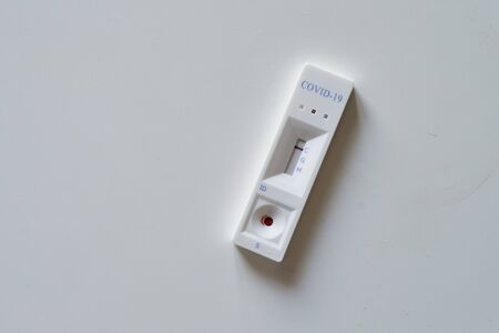 Negative test result by using rapid test device for COVID-19 novel coronavirus on a home kitchen table.の写真素材