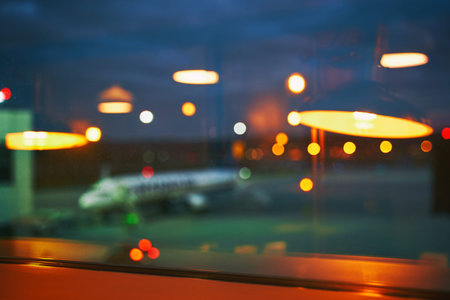 Blurred or defocused beautiful airport terminal early morning or night background with airplane,...