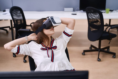 Female professional using vr virtual reality headset at desk in office