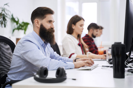 People working in modern IT office. Group of young and experienced programmers and software...