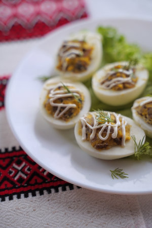 Deviled eggs aka stuffed eggs. Traditional Ukrainian food on the table with embroidered tablecloth.の写真素材