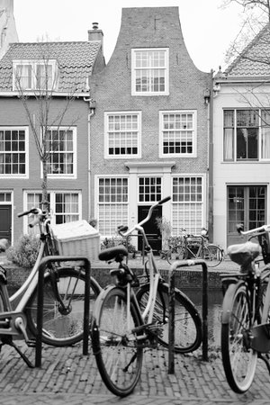 Picturesque Netherlands in black and white. Bicycles parked alongside a channel on beautiful old...