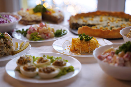 Homemade food on a festive New Year table with focus on mimosa salad.の写真素材