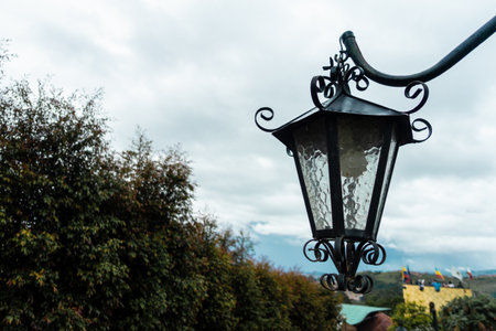 Antique old street lamp at day with cloudy sky backgroundの写真素材