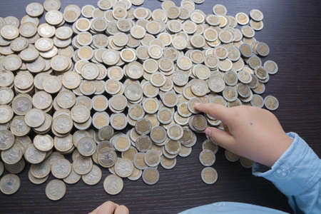 Open savings over a wooden table for financial crisis with Colombian coinsの写真素材