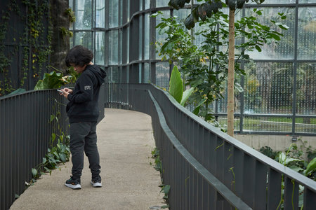 A young man using a mobile phone in a public park in Bogota