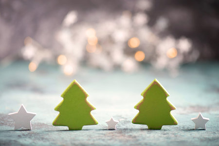 Christmas trees and star with blury lights in the background, greeting card, empty copy space