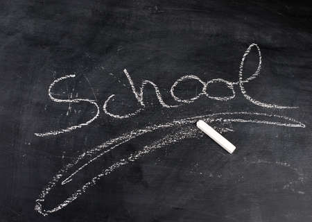 The word school written with chalk on a blackboard, end of vacationsの写真素材