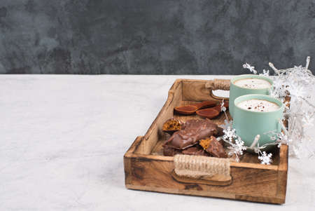 Coffee cups and chocolate coated gingerbread in a wooden basket, empty copy space, christmas seasonの写真素材