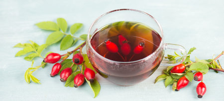Hip rose tea with fresh fruits and leaves, hot drink
