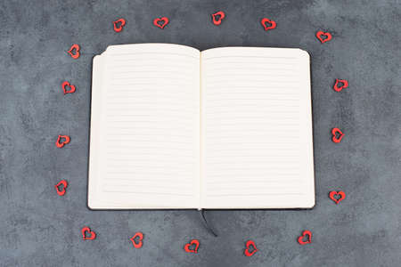 Empty notebook with wooden hearts and a penの写真素材