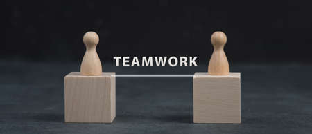 Two wooden people connect to build a team, working togetherの写真素材