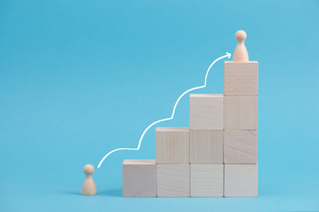 Wooden cubes building stairs, on person is standing at the bottom and the other men is standing on...