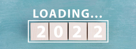 2022 is standing in white colored letters on wooden cubes, the word loading is standing above
