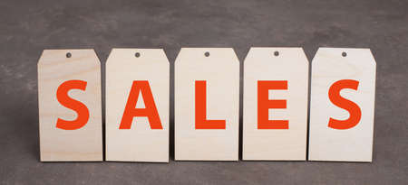 Tags with the word sales in red color, dark textured background, empty copy spaceの写真素材