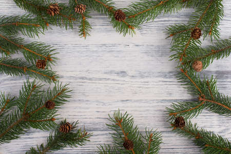 Christmas backdrop with branches of fir, empty copy space in the middle, wooden backgroundの写真素材