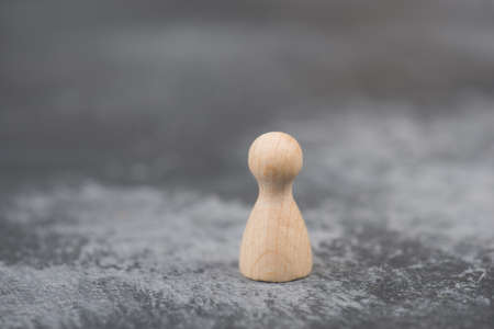 Person is standing alone, separated from the group, symbol lonelisness, dark colored backgroundの写真素材