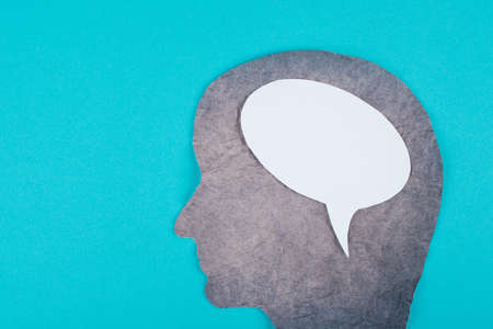 Silhouette of a face made with scrambled paper, speech bubble in white color, copy space for text, communication, symbolicの写真素材