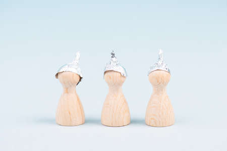Three wooden figures wearing an alu hat, conspiracy theories, tin foil, symbolicの写真素材