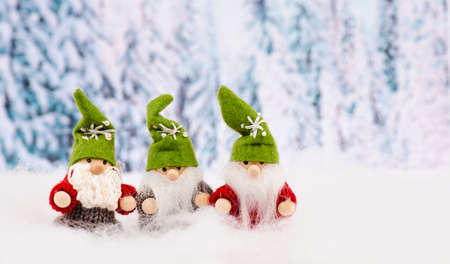 Little cute christmas elves standing in the snow, forest, festive greeting card, copy space, wintertimeの写真素材