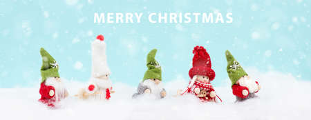 Little cute girls and christmas elves standing in the snow, festive greeting card, copy space, wintertimeの写真素材