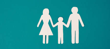 Parents with one child holding hands, paper cut out, copy space, petrol colored background, relationshipの写真素材