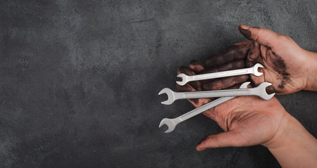 Holding wrench tools in the hands covered with fuel oil, repairing tools, industrial worker, copy...