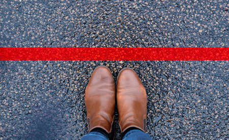 Red line on the road, someone is standing in front of the stop, covid-19 restrictions, having your own space, do not crossの写真素材