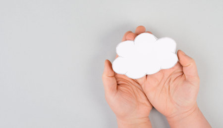 Holding a white cloud in the hand, empty copy space for text, gray background, communication and...