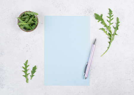 Blank colored paper with a pen, arugula salad leaves, copy space for text, recipe for cooking, preparing food, healthy lifestyle, dietの写真素材