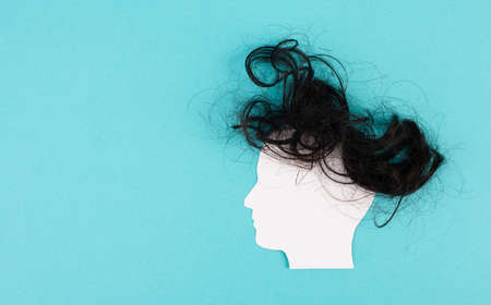 Silhouette of a face with a hairstyle, woman, man, transgender, copy space for text, portrait with dark hair, paper cut outの写真素材