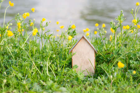 Wooden house in a meadow, buying or renting a house in nature, real estate concept, booking home for vacation, copy space for textの写真素材