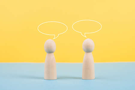 Two people talking together, empty speech bubbles, having a conversation, networking and teamwork concept, social issueの写真素材