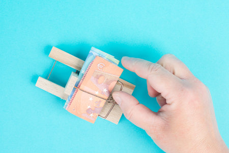 Euro banknotes in a mousetrap, bank loan, financial debt, inflation, risky credit and investment,...