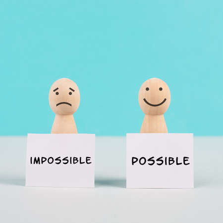 Two men holding signs, possible and impossible concept, mindset of an optimist and a pessimist, change the attitude for progressの写真素材