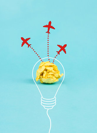 Red airplanes flying out of a crumpled yellow paper, brainstorming for ideas in a team, startup in business, having a goal, positive mindsetの写真素材