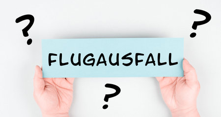 The word flight cancellation is standing in German language on the paper, staff shortage at the...