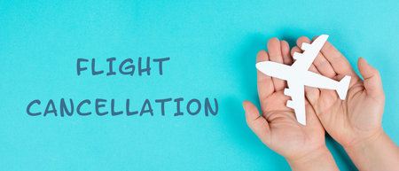 Holding an airplane in the hands, flight cancellation is standing on the paper, staff shortage at...