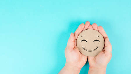 Holding a smiling happy face in the hands, positive emotions, good customer feedbackの写真素材