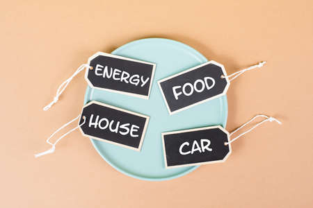 Globally increasing prices, high living expenses, food, house, car and energy costs standing on tags, empty plate, inflationの写真素材