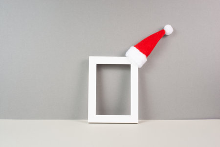 Home interior poster mock up with wooden frame, a red Santa Claus hat, greeting card for christmas, copy space for text and picturesの写真素材