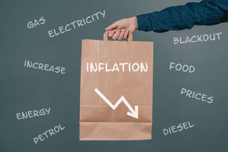 Inflation and financial crash, man holding empty shopping bag, economic development and increasing prices for food and energyの写真素材