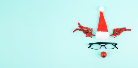 Reindeer with a red bauble nose, antlers, a santa claus hat and eyeglasses, merry christmas greeting cardの写真素材