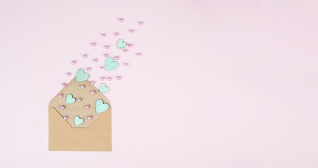 Valentine day greeting card, envelope with hearts on pastel background, love symbol, flat layの写真素材